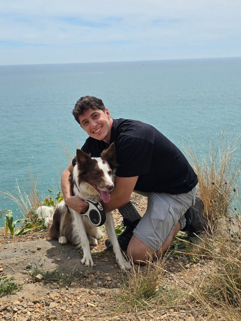 David y Loki, border collie marrón y blanco, en un acantilado con vistas al mar
